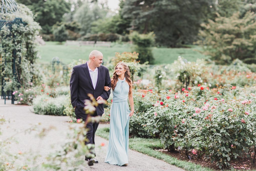 couple walks in garden during engagement session with M Harris Studios