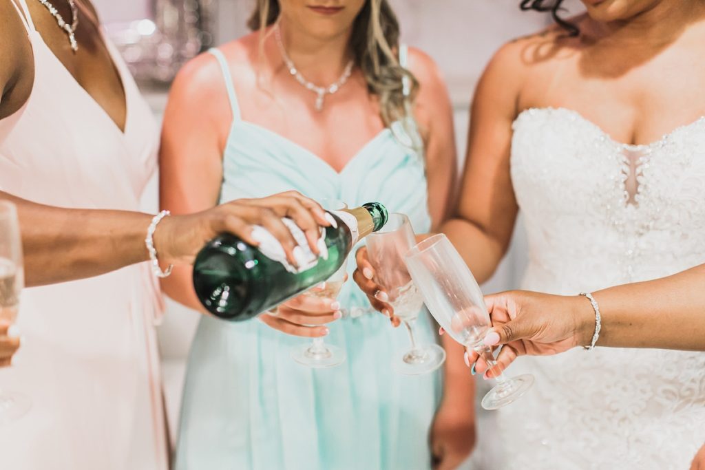 bridesmaids pop the champagne photographed by M Harris Studios